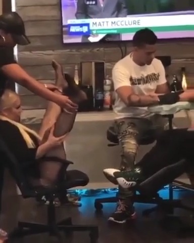 Gostosa de perna aberta servindo de modelo para tatuador no estúdio