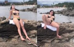 Morena sensual exibindo o corpo pelado na praia enquanto faz uma siririca provocante